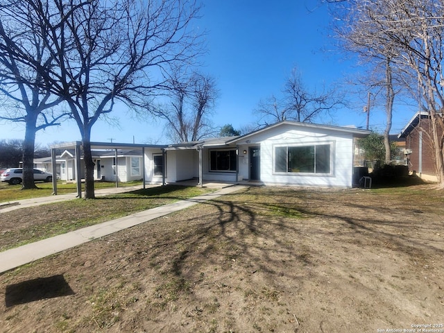 ranch-style home featuring a carport, a front lawn, and driveway