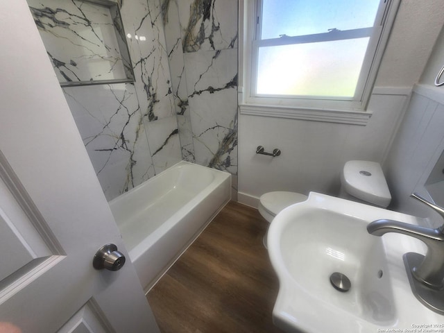 full bathroom featuring a wainscoted wall, a sink, toilet, and wood finished floors