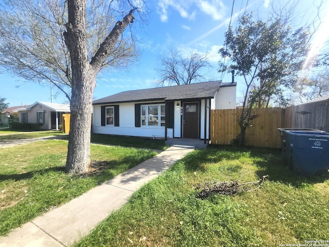 view of front of property featuring a front yard, fence, and stucco siding