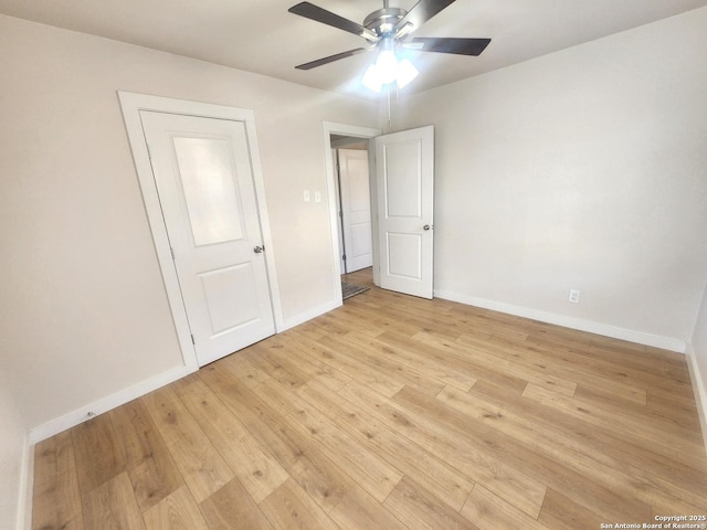 unfurnished room featuring ceiling fan, light wood-type flooring, and baseboards