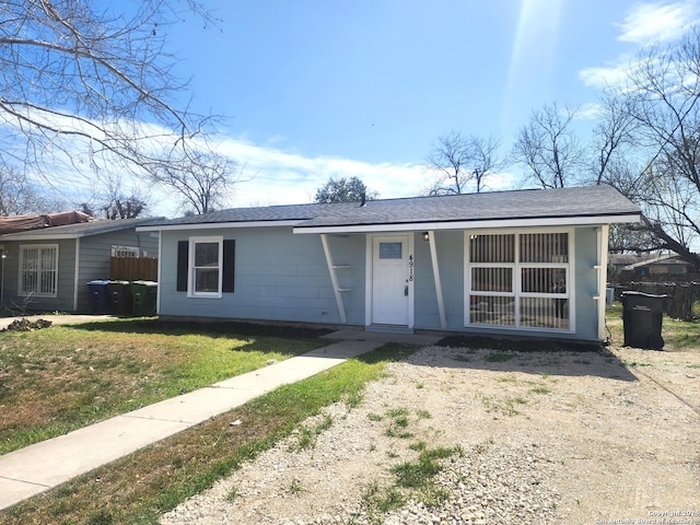 single story home featuring a shingled roof and a front lawn