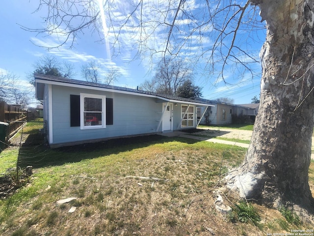 view of front facade featuring fence and a front lawn