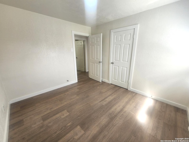 unfurnished bedroom with baseboards and wood finished floors