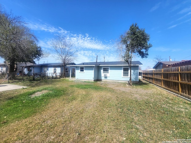 rear view of property featuring a lawn and fence private yard