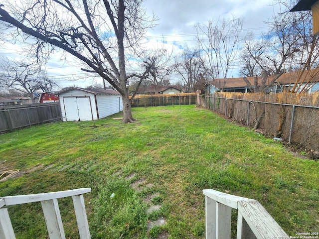 view of yard featuring an outbuilding, a shed, and a fenced backyard