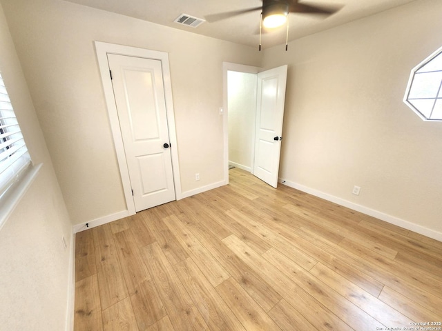 unfurnished bedroom with ceiling fan, light wood-style flooring, visible vents, and baseboards