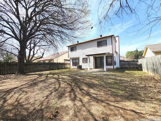 rear view of house featuring central AC, a lawn, and a fenced backyard