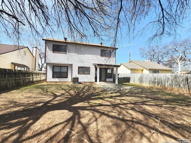 back of house with a fenced backyard and a patio