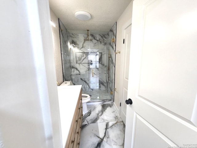 full bathroom featuring marble finish floor, a marble finish shower, toilet, vanity, and a textured ceiling