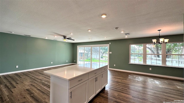 kitchen featuring open floor plan, baseboards, dark wood-style flooring, and white cabinets