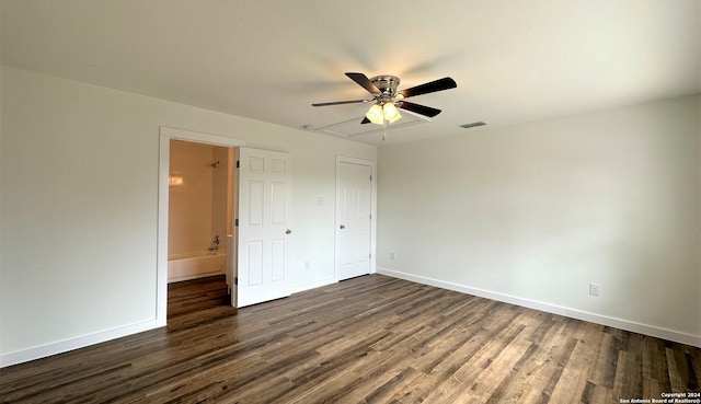 unfurnished bedroom featuring dark wood-style flooring, visible vents, and baseboards