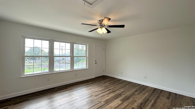 spare room featuring ceiling fan, dark wood-style flooring, and baseboards