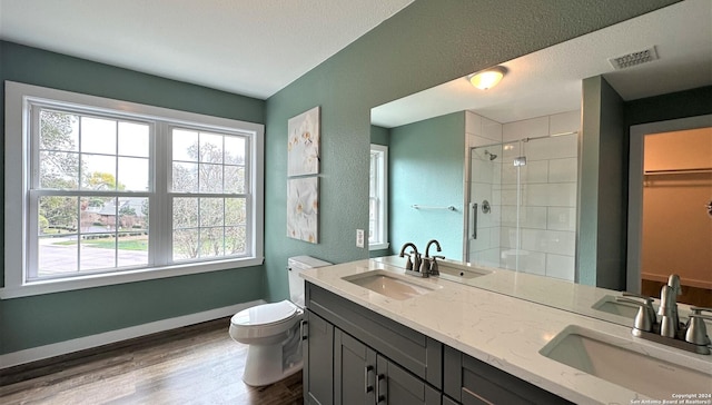 full bathroom featuring a stall shower, visible vents, a sink, and toilet