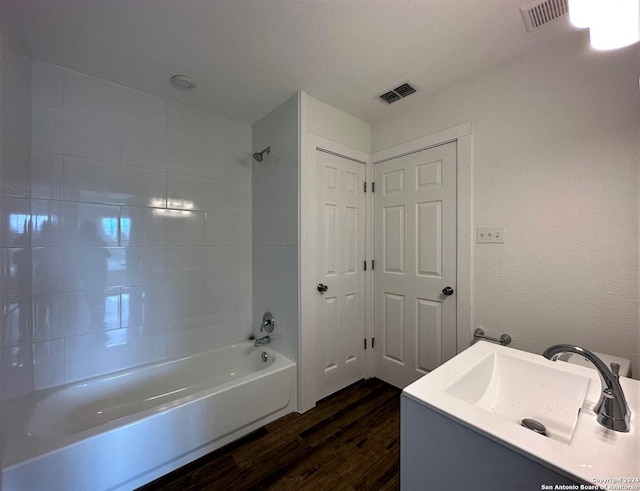 full bathroom featuring visible vents, vanity, shower / tub combination, and wood finished floors