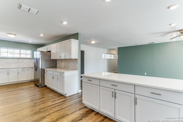 kitchen featuring visible vents, light wood-type flooring, plenty of natural light, and freestanding refrigerator