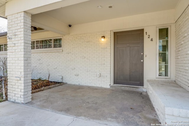 property entrance featuring brick siding