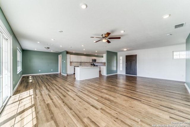 unfurnished living room with light wood finished floors, visible vents, and recessed lighting