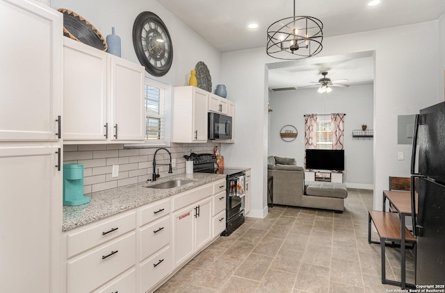 kitchen featuring black appliances, tasteful backsplash, a sink, and a wealth of natural light