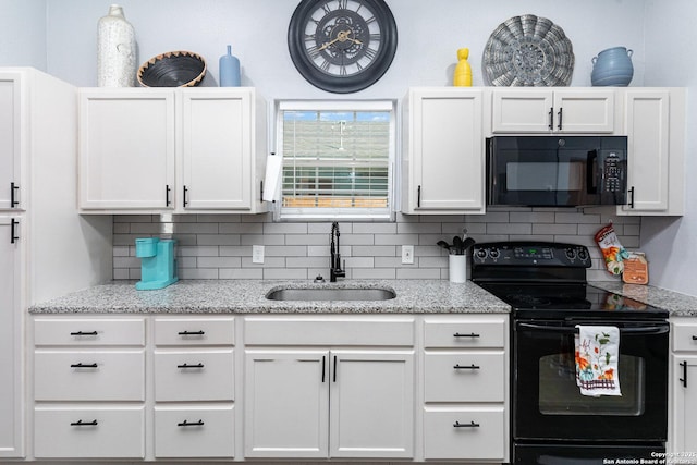 kitchen featuring decorative backsplash, white cabinets, a sink, and black appliances