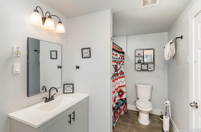 bathroom featuring toilet, vanity, and visible vents