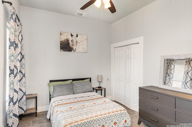 bedroom with a ceiling fan, baseboards, visible vents, and a closet