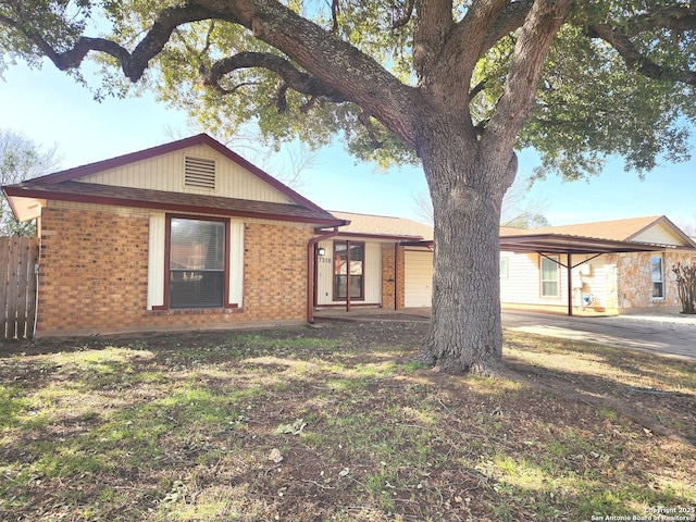 ranch-style house featuring brick siding and fence