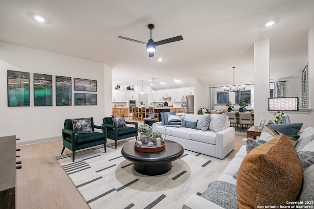 living room featuring recessed lighting, baseboards, light wood finished floors, and ceiling fan with notable chandelier