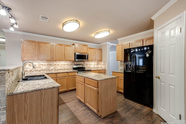 kitchen featuring light brown cabinets, appliances with stainless steel finishes, decorative backsplash, and a sink