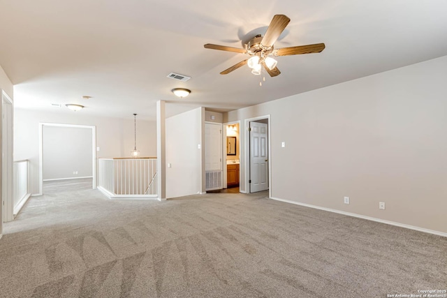 empty room featuring light carpet, baseboards, visible vents, and ceiling fan