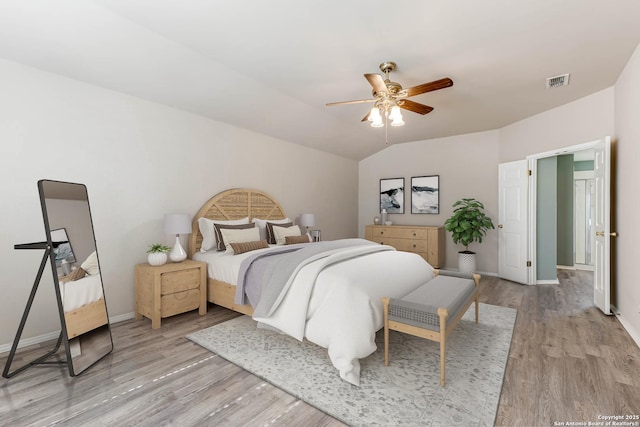 bedroom featuring vaulted ceiling, light wood-type flooring, visible vents, and baseboards