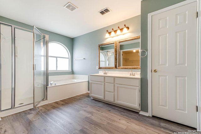 full bath featuring a garden tub, a sink, and visible vents