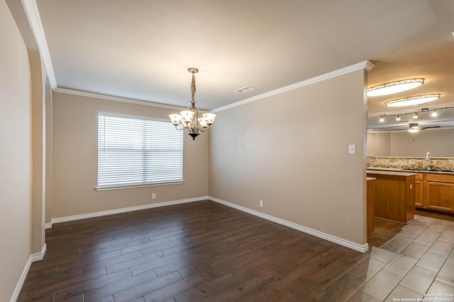 spare room with a notable chandelier, visible vents, baseboards, ornamental molding, and dark wood finished floors