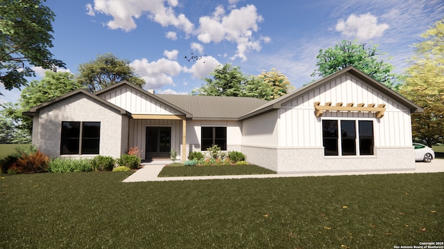 rear view of house with a yard, a shingled roof, board and batten siding, and brick siding