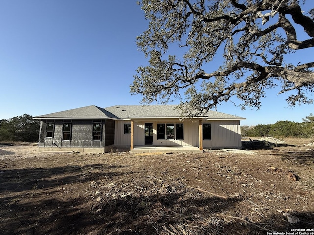 rear view of property with a patio and board and batten siding