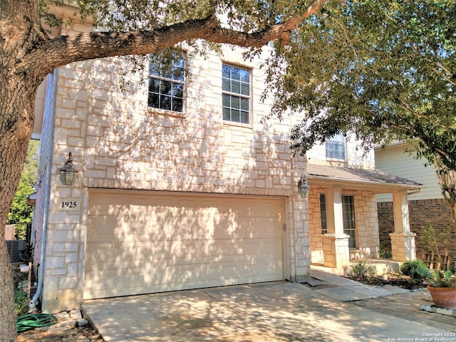 view of front of property featuring stone siding, driveway, and an attached garage