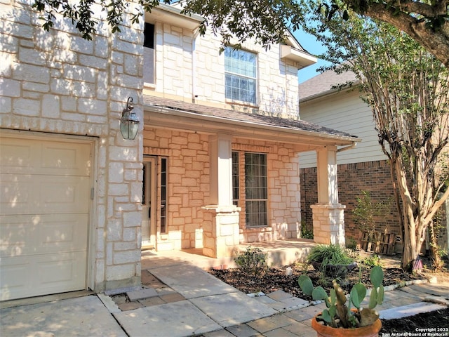 view of front facade with a porch, stone siding, and a shingled roof