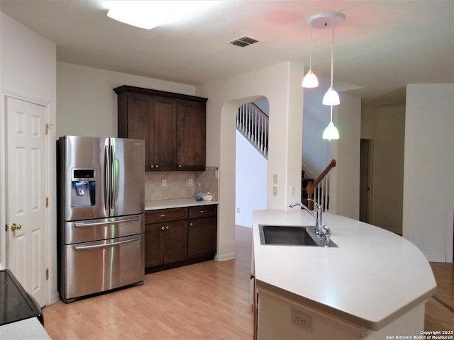 kitchen with dark brown cabinetry, visible vents, decorative backsplash, stainless steel fridge with ice dispenser, and a sink