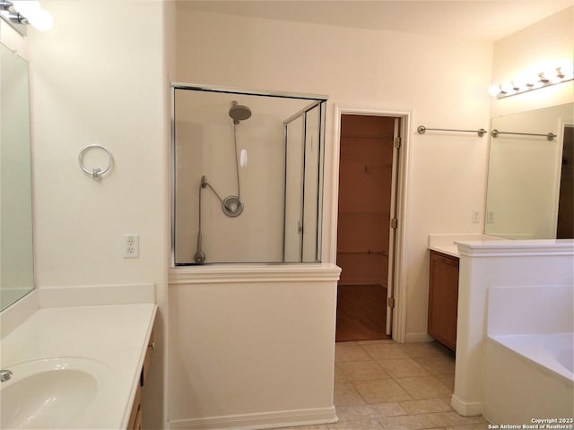 bathroom with a garden tub, tile patterned flooring, a sink, two vanities, and a shower stall