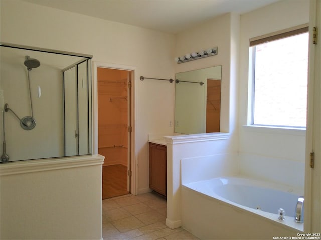 bathroom featuring a shower stall, a spacious closet, a tub with jets, and tile patterned floors