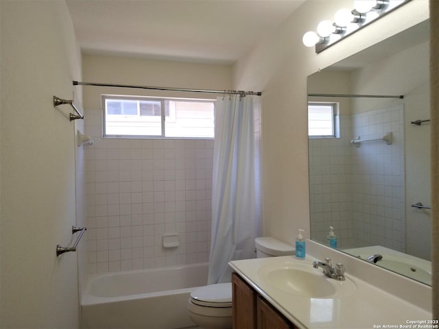 bathroom featuring toilet, shower / bath combo with shower curtain, and vanity