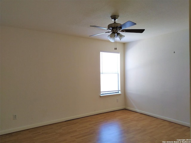 unfurnished room with light wood finished floors, ceiling fan, and baseboards