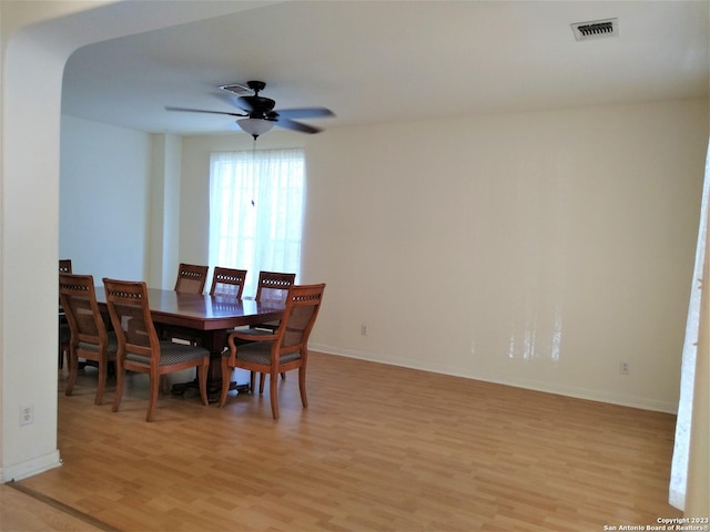 dining area featuring a ceiling fan, light wood-type flooring, visible vents, and baseboards