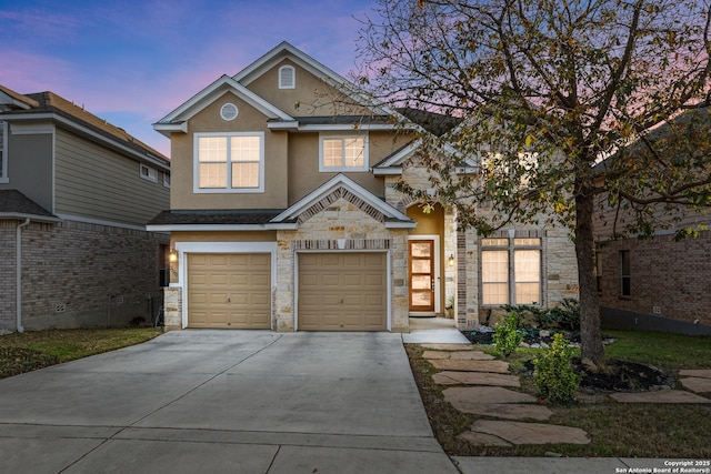 view of front of house with driveway, stone siding, an attached garage, and stucco siding