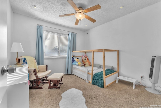 carpeted bedroom with heating unit, a ceiling fan, and a textured ceiling