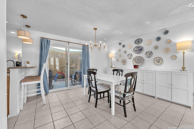 dining area featuring light tile patterned floors, a chandelier, and a textured ceiling