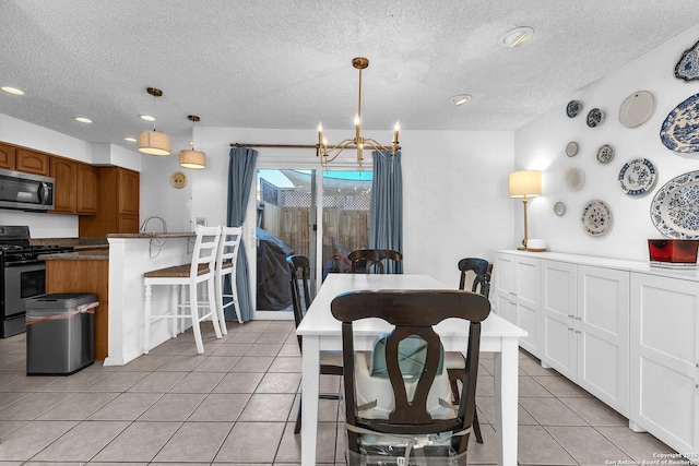 dining room featuring a notable chandelier, a textured ceiling, and light tile patterned floors