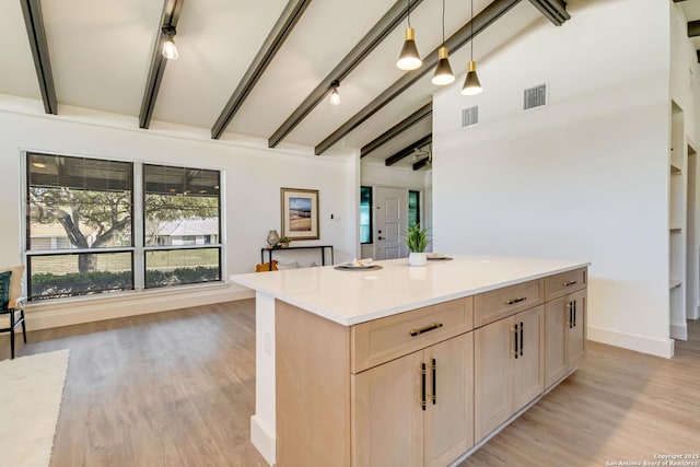 kitchen featuring visible vents, light wood finished floors, and a kitchen island