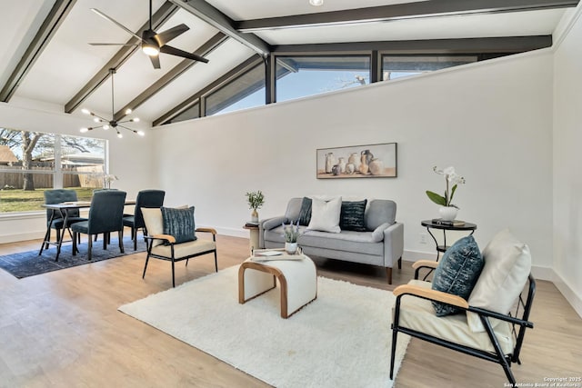 living room featuring beam ceiling, high vaulted ceiling, ceiling fan with notable chandelier, light wood-style floors, and baseboards