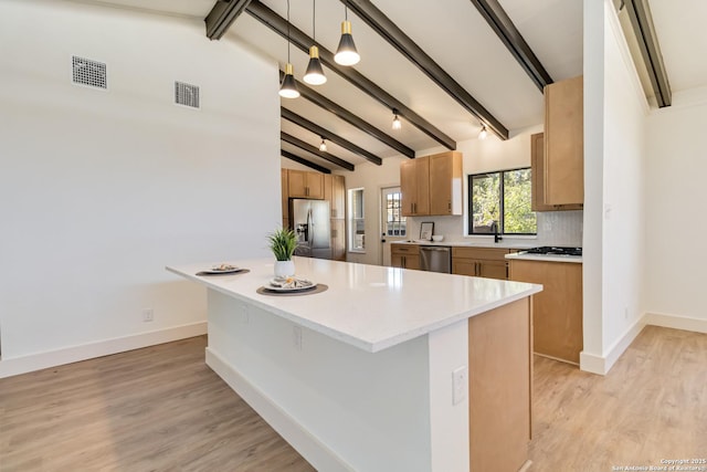 kitchen with visible vents, lofted ceiling with beams, a sink, decorative backsplash, and stainless steel appliances