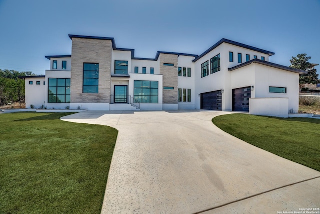 contemporary house with a front yard, stone siding, an attached garage, and stucco siding